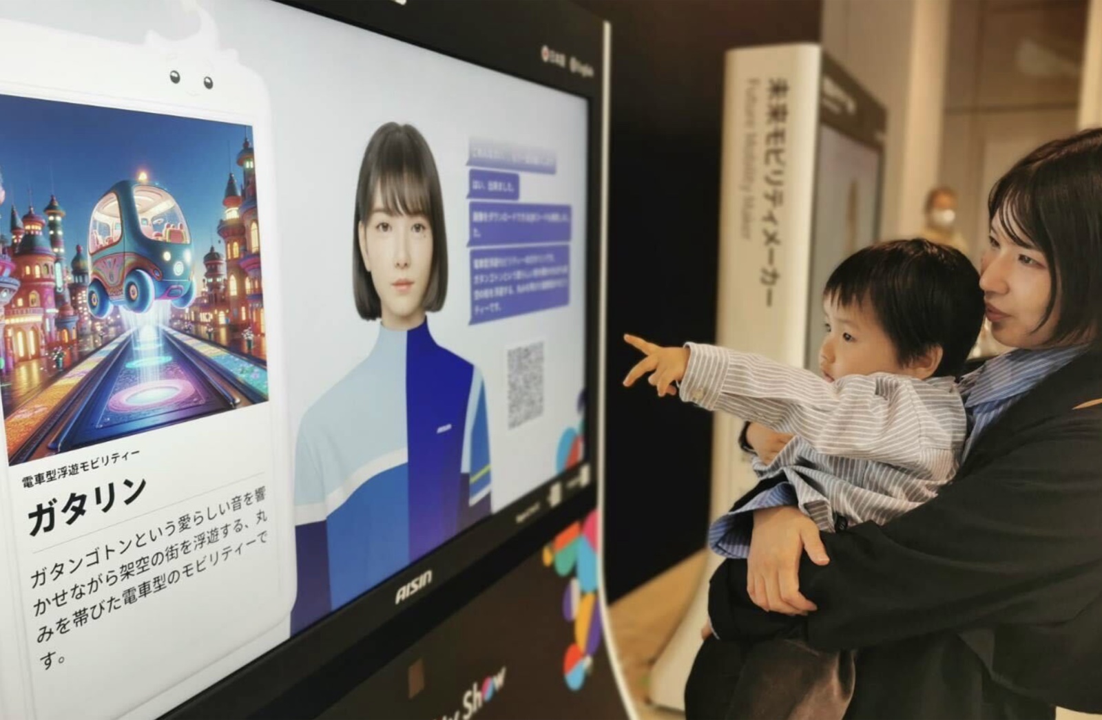 Future Mobility Maker exhibit: a child pointing at the AI agent and a generated vehicle on screen